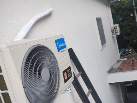 Unidade externa de ar-condicionado recém-instalada pela New Clima, com a tubulação encapada e presa rente à parede.